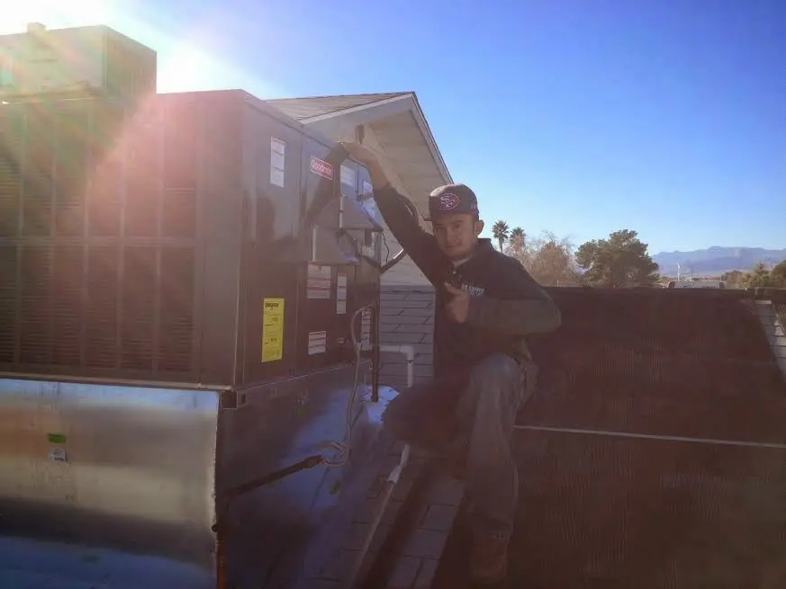 HVAC technician performing AC Tune-Up on a rooftop unit in Pittsburg